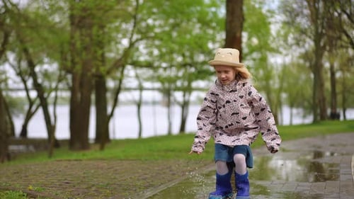 A Joyful Child is Happily Playing in Puddles on a Wonderful Rainy Day Full of Fun