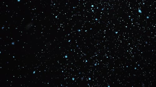 Blaue Glitzerpartikel fallen in Lichtstrahlen