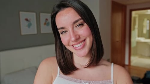 Close up of Happy Young Woman Smiling in Bedroom