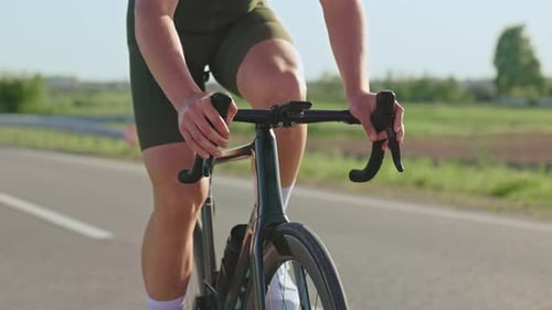 Cyclist Rides Bicycle on Rural Road