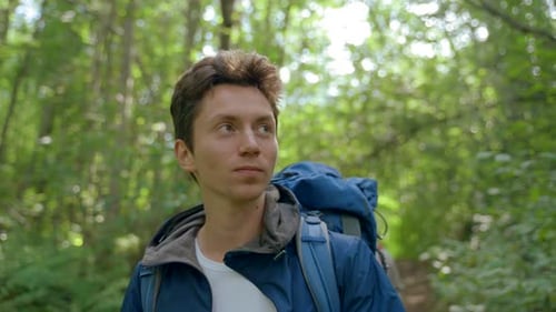 Young Adults Hiking Through Forest With Backpacks