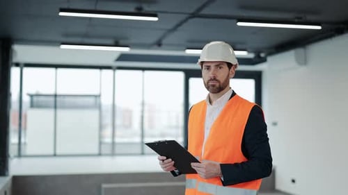 Confident Engineer Inspects New Office Building with Checklist
