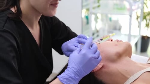 Woman getting cosmetic injection in face at clinic