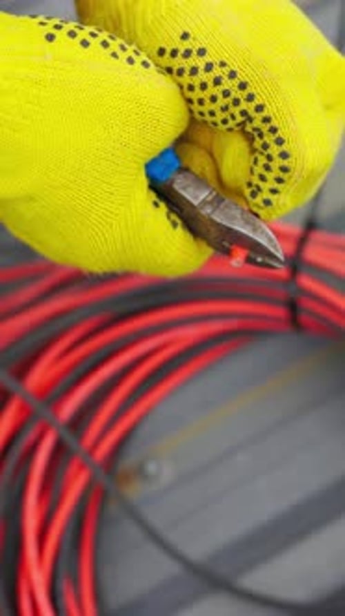 Electrician Stripping Insulation from Orange Electrical Wire