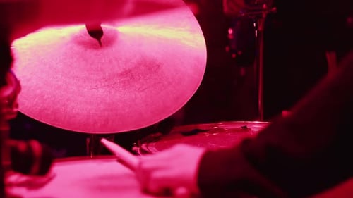 Drummer Playing Drums with Pink Stage Lighting