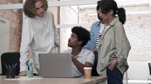 African American Man Explaining Ideas and Project to Young Team of Diverse Coworkers in a Modern
