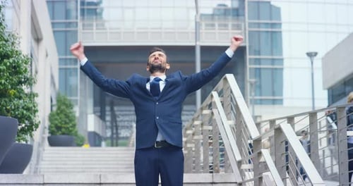 Man in Suit Celebrates Success in Urban Setting