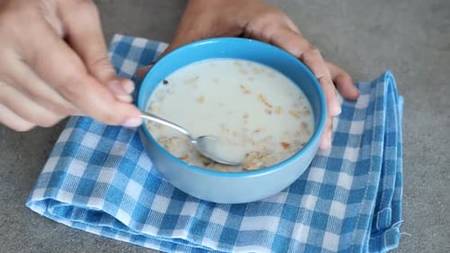 Stirring Milk and Cereal in Bowl at Home