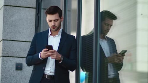Close Up Handsome Man Standing with Phone Near Modern Building Outside. Successful