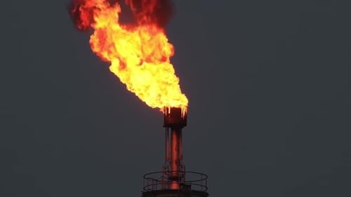 Petroleum refinery gas flare blazing fire with black smoke against night sky from chimney stack