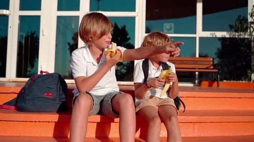 Students Eating Lunch in School Yard During Break Sitting on the Porch