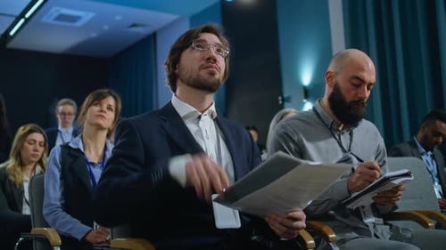Conference Attendees Listening in Meeting Indoors