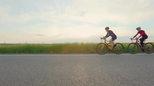 Two Male Triathletes Racing on Bicycles on Country Road
