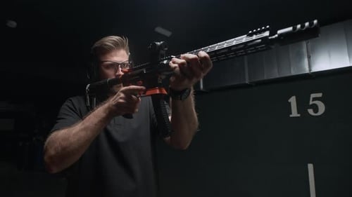 Man Shooting Rifle at Indoor Shooting Range