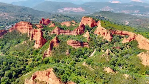 Bare rocks sticking out of the greenery. Sunny view of the vast mountainous landscape of Spain