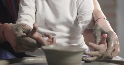 Child Learning to Make Clay Pot on Pottery Wheel