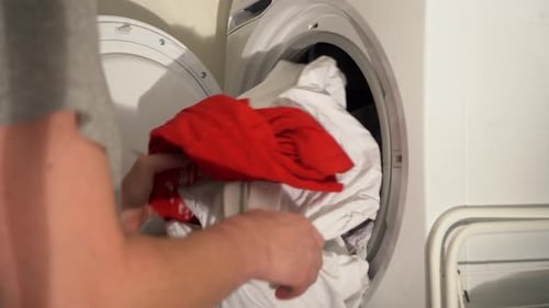 Man Unloads Clothes from Laundry Dryer