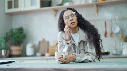 Woman Contemplating with Mug in Kitchen