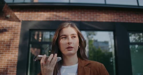 Camera Holding Focus on Beautiful Caucasian Girl Woman Walking Out of Building and Talking to