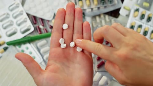 Closeup of Pills in a Woman's Hand Taking Medicines Bought in a Pharmacy