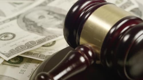 Gavel Resting on Pile of One Hundred Dollar Bills