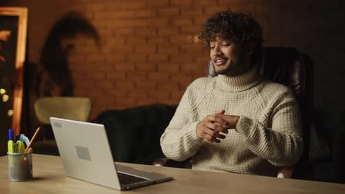 Young Man Video Conferencing at Desk Indoors