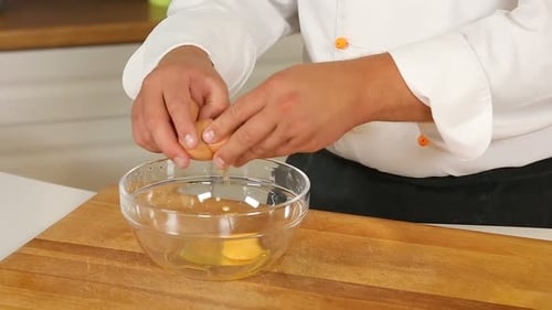 Chef Cracking Eggs into Bowl for Cooking