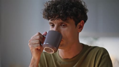 Young Adult Man Drinking Coffee and Thinking