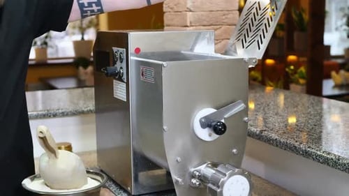 Chef Loading Dough Into Pasta Machine