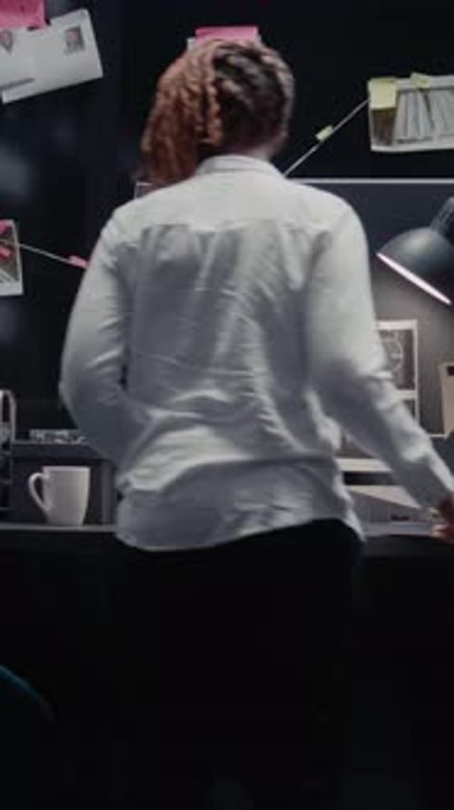 Investigator Analyzes Case Files in Dark Office