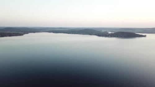 Expansive aerial view of Lake Wisconsin at twilight with still water and distant hills