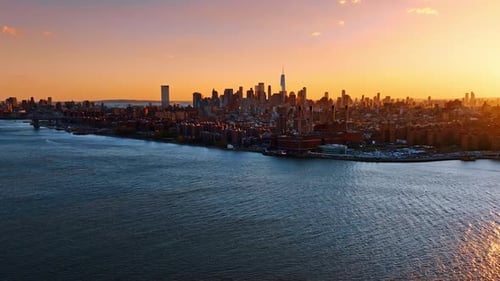 Amazing scenic view of New York skyline at sunset. Beautiful orange sky above the metropolis