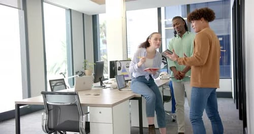 Collaborating on project ideas, colleagues using tablet and notepad in modern office