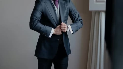 Man in Formal Suit Buttoning Jacket in Mirror