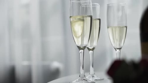 Close up of elegant bubbly champagne flute glasses on a white wedding table
