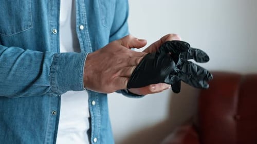Man Putting On Black Protective Rubber Gloves