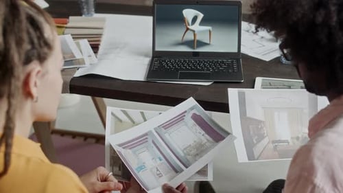 Interior Designers Looking at 3D Rendering Pictures at Workplace