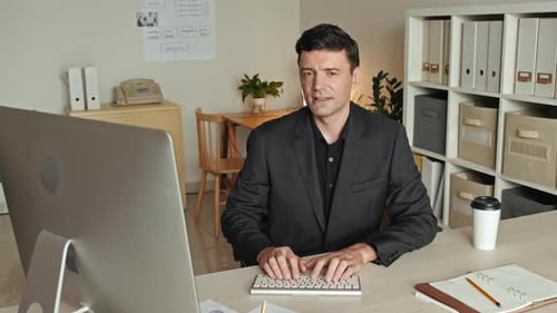 Portrait of Businessman Working on Computer in Office
