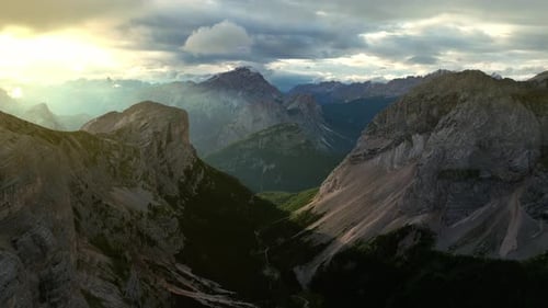 Drone shot capturing the ethereal beauty of the Dolomites bathed in morning light, with steep cliffs
