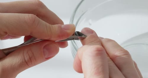 Woman Trimming Cuticles During Home Manicure Procedure