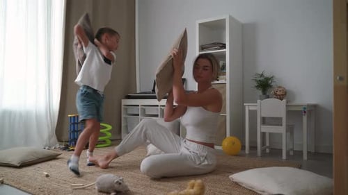 Mother and Child Enjoying a Pillow Fight at Home