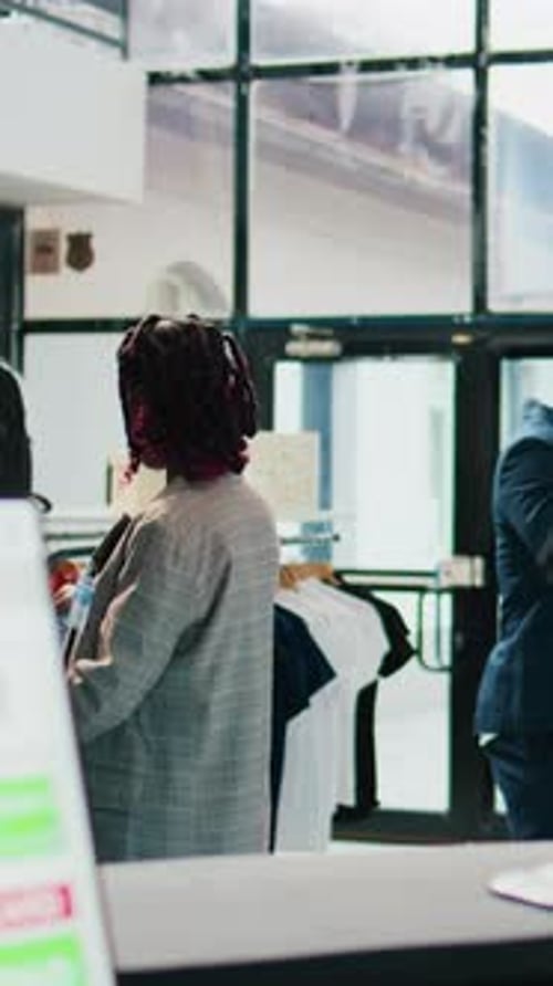 Vertical Video Pregnant Woman Looking at Trendy Merchandise on Stand Hangers