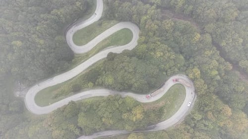 Top down drone view of winding mountain road in fog in the Pyrenees
