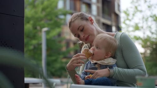 Mother Feeding Baby Ice Cream In The City