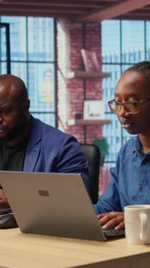 Homme et femme afro-américains travaillant à distance dans leur appartement