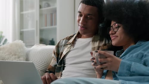 Couple Relaxing Together at Home With Laptop