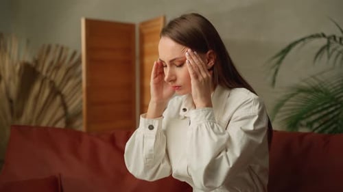 Woman Massaging Temples To Relieve Headache