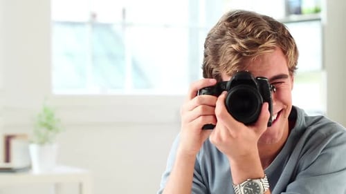 Smiling Young Man Takes a Photo