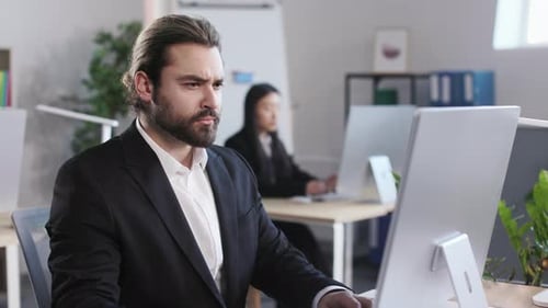 Businessman Typing on Computer Keyboard at Modern Office