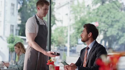 Businessman Paying Contanless Technologies Using Smartphone in Restaurant